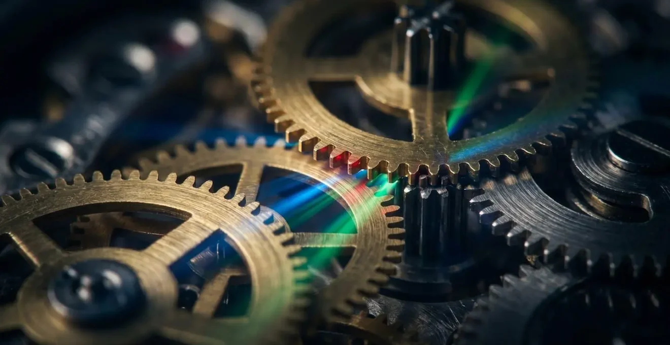 Macro shot of precision mechanical gears with light beams showing perfect synchronization